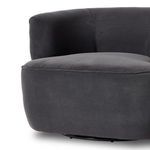 Chair at an angle showing smooth charcoal fabric upholstery and curved back