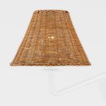 Close-up of three rattan shades on white chandelier arms illuminated from within