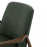 Close-up on padded backrest seam and oak frame armrest junction