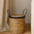 Bamboo stool with lid in natural room setting on wooden floor beside curtain and sofa