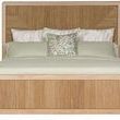 Modern California King bed with light wood frame and neutral woven upholstered panels, featuring curved wood trim