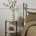 Vesper Oval Nightstand styled with decorative vase and sculpture in bedroom setting