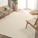Solid beige rug styled in a sunlit living room with wood furniture and natural accents