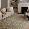 Wade Sage Gold Rug styled in a modern living room with neutral sofa and fireplace