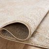 Close-up of rug folded to reveal soft polyester texture and backing on wooden floor