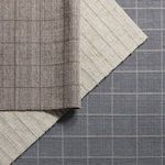 Three rugs overlapping showing color variations: gray/taupe, cream, and blue with grid weave