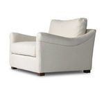 Side angle of Bridges Natural Chair And A Half showing contoured arm curves and thick seat cushion