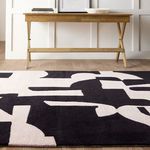 Low side angle highlighting rug's thickness and wool-viscose pile next to wooden console table
