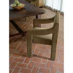 Elise Dining Chair placed on terracotta tile floor next to wooden dining table, side view