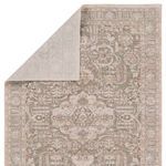 Back side of the rug flipped to reveal lighter woven underside in neutral tones