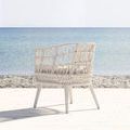 Dana Rope Dining Chair back right 3/4 view showing wrapped legs and woven side detail against ocean