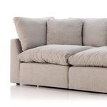 Side angle showing thick, plush feather-blend seat cushions and fabric upholstery of sofa corner