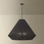 Keats Pendant hanging from ceiling with chain visible, lit to show subtle shadows on beige wall background