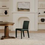 Monte Dining Chair in styled dining room with wooden round pedestal table, rug, and white shelves