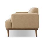 Side view of Ethel Sofa showing thick armrest and rounded wood base with tapered leg