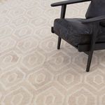 Deco Natural Rug under black cushioned armchair showing scale and pattern around furniture legs