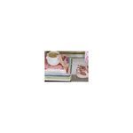 Blush pink sea glass beads styled over books and a mug on a shelf in home decor setting