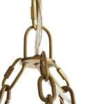 Close-up detail of brass hanging loop with electrical wiring threaded through brass chains