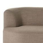 Close-up detail of soft rounded backrest and curved sofa arm enveloped in upholstery.