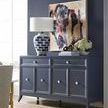 Room setting with blue wall, navy blue sideboard, abstract wall art, and Josie Accent Chair corner