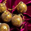 group of several brown and gold flocked glass ornaments resting on deep magenta velvet fabric