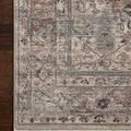 Close-up of rug corner showing intricate border pattern and soft texture on wooden floor