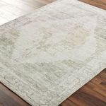Close-up angled view of Luca Olive rug showing woven texture and soft muted coloring on hardwood floor