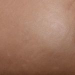Detailed texture shot showing smooth, lightly distressed warm taupe leather surface