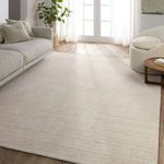 Cream striped rug styled in bright living room with neutral sofa, round chair, and wood flooring