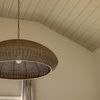 Wicker pendant shown in room with pitched ceiling, curtains, and window in background