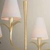 Close-up of central stem and two white linen shades with leaf-shaped gold arms
