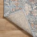 Corner of rug lifted to reveal underside and detailed weaving