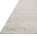 Angled close-up showing the thick, sturdy edge and textured weave of the ivory pebble geometric rug