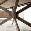 Underneath view of black iron pedestal base with visible bolts and support structure