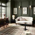 Humphrey Forest rug styled in a dark green paneled living room under a tufted cream sofa.
