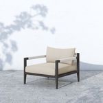 Sherwood chair shown outdoors on stone tile with shadow of tree branches