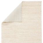 Rug corner flipped to reveal soft, solid cotton backing under woven white and beige surface