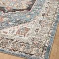 Close-up of rug pattern focusing on a section of the blue border and intricate surrounding motifs