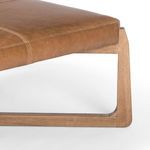 Side view close-up showing curved wooden leg detail and leather top edge