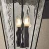Close-up of Jantzen Wall Sconce showing wavy textured glass and candle-style bulbs lit