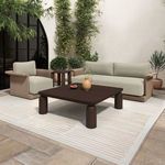 Outdoor setting featuring Meredith chair next to sofa and dark wood coffee table on area rug