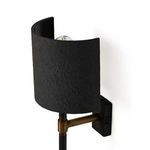 Maurice Sconce close-up of textured black curved shade and brass arm from side angle
