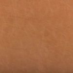 Close-up of rich textured tan leather upholstery with natural grain on armrest