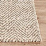 Corner of Chevron jute rug on wood floor highlighting thick woven texture and edge detail