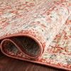 Rolled corner of the rug highlighting pile thickness and woven texture against dark wood flooring