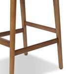 Close-up of the wood stool leg and footrest connection showcasing wood grain finish