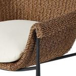Detail of rolled armrest wrapping around black metal chair frame above white cushion