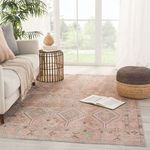 Living area with Marquesa rug accented by leather sofa, woven ottomans, and striped throw blanket.