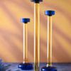 Three yellow and blue glass candle holders in varying heights with soft warm background light