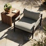 Sherwood Faye Ash Bronze Chair styled outdoors with wooden side table, potted plant, and soft sunlight